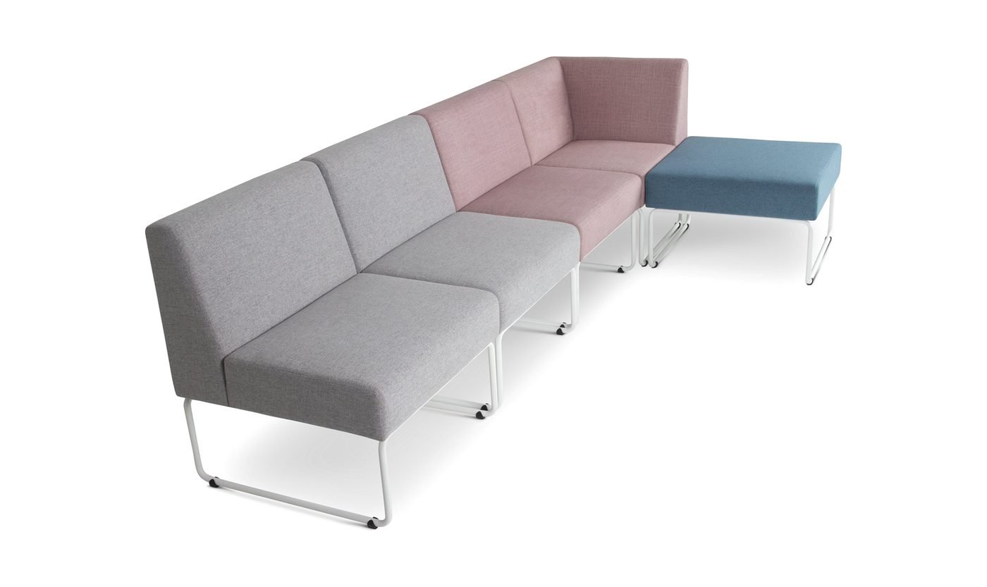 Sofá modular em L com módulos cinza e rosé e pufe azul.